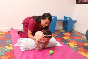 Niña en consulta de fisioterapia con profesional