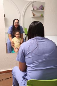 Niña en consulta de fonoaudiología con profesional