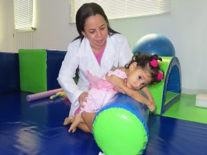 Niña e consulta de fisioterapia con profesional