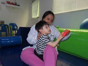Niño en consulta de fisioterapia con profesional